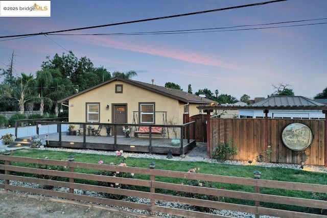 view of front of house with a deck and a lawn