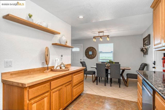 kitchen featuring stainless steel dishwasher, butcher block countertops, and light tile patterned floors