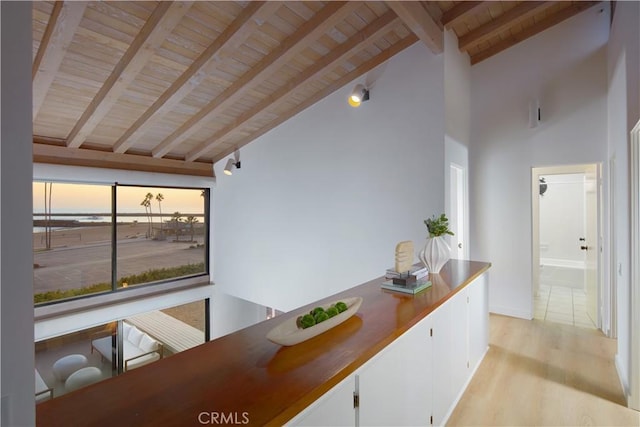 dining space featuring wooden ceiling, light hardwood / wood-style floors, high vaulted ceiling, and beamed ceiling