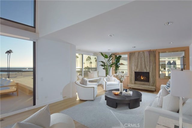 living room with light wood-type flooring and a high end fireplace