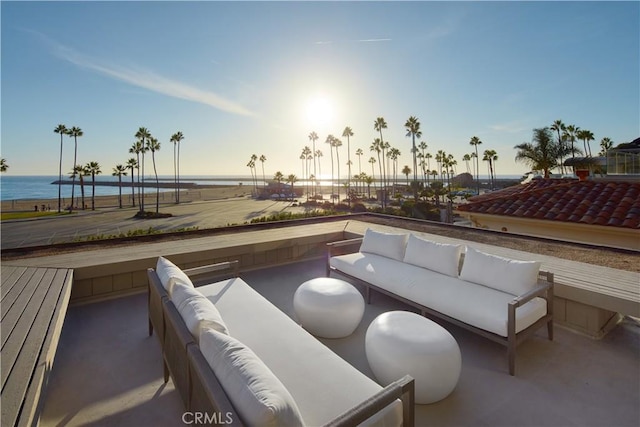 patio terrace at dusk featuring a water view and outdoor lounge area