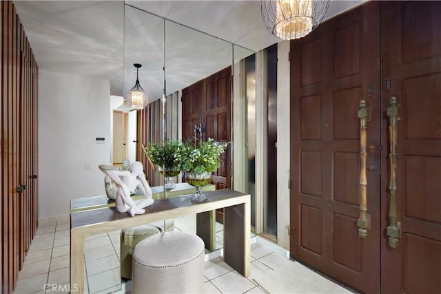 entryway featuring light tile patterned floors and a notable chandelier