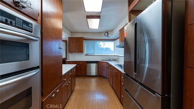 kitchen featuring stainless steel appliances, light hardwood / wood-style flooring, and sink