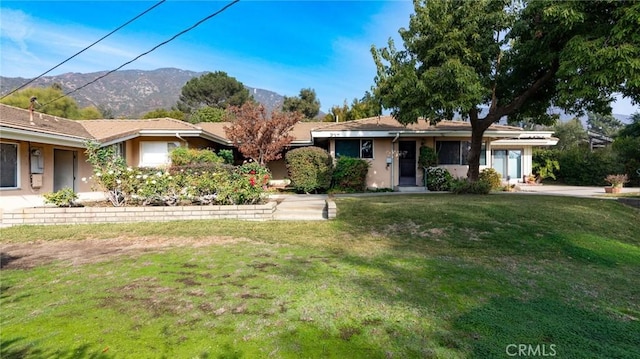 ranch-style home featuring a mountain view and a front yard