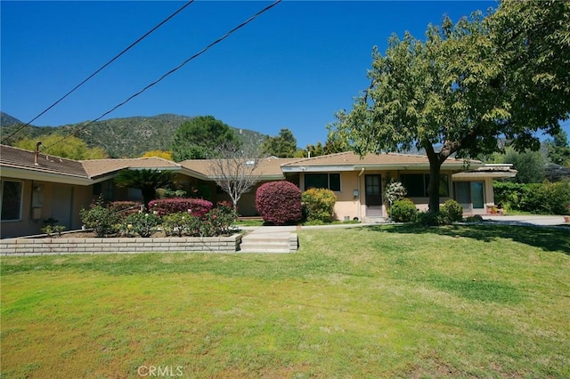 single story home featuring a mountain view and a front lawn