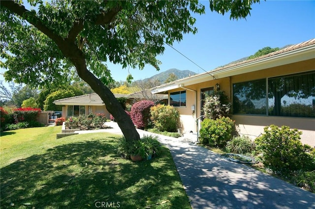 ranch-style home with a mountain view and a front yard