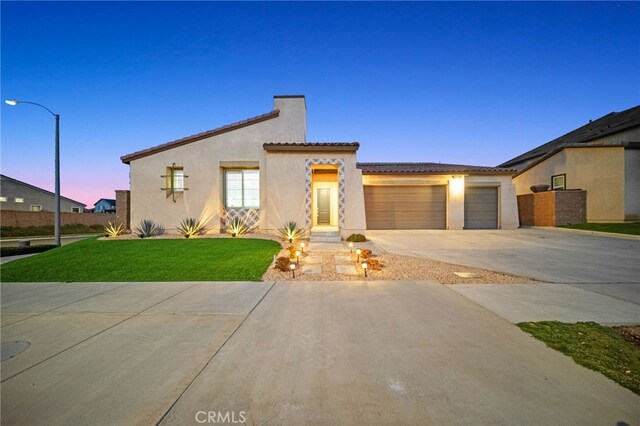 view of front of property with a yard and a garage