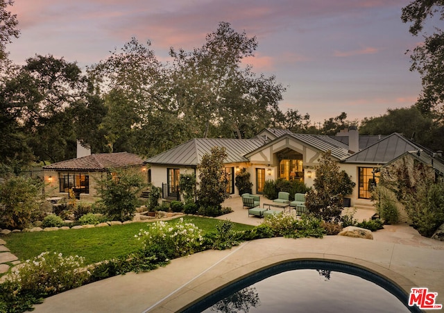 view of front of property featuring a patio area and a yard