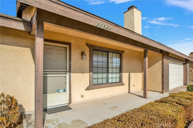 property entrance with covered porch and a garage