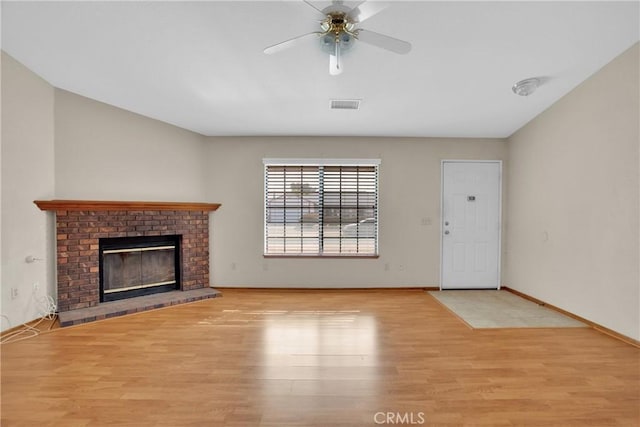 unfurnished living room featuring a fireplace, ceiling fan, and light hardwood / wood-style floors