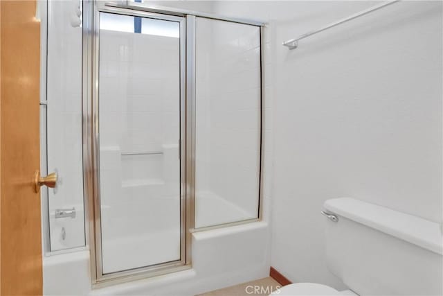 bathroom with toilet and combined bath / shower with glass door