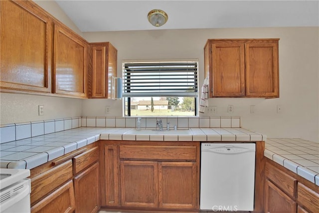 kitchen featuring tile counters, sink, and white appliances