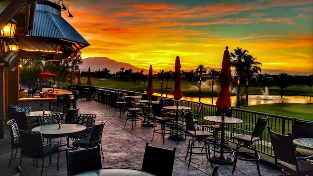 patio terrace at dusk featuring a mountain view