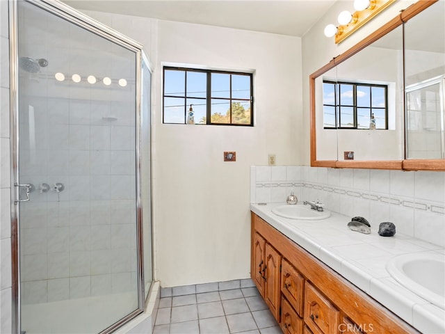 bathroom featuring tile patterned floors, plenty of natural light, vanity, and a shower with shower door