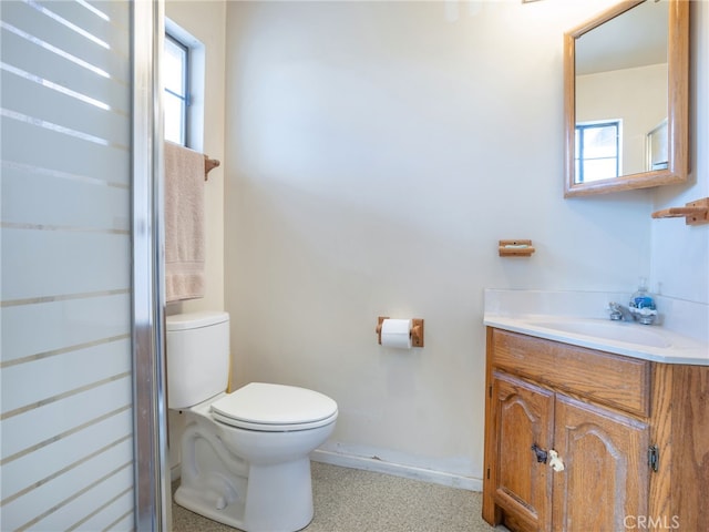 bathroom featuring toilet, a healthy amount of sunlight, and vanity