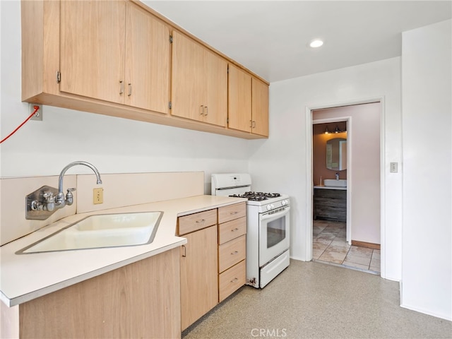 kitchen featuring sink, light brown cabinets, and white gas range