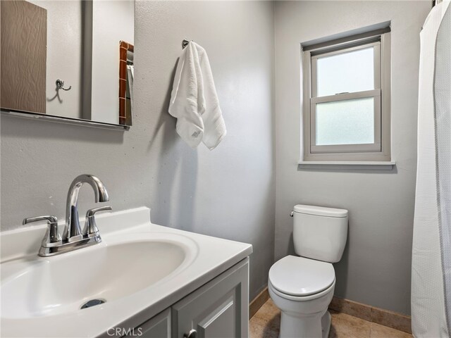 bathroom with toilet, tile patterned floors, and vanity