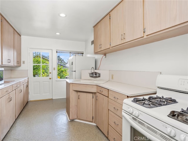 kitchen featuring light brown cabinets, sink, and white appliances