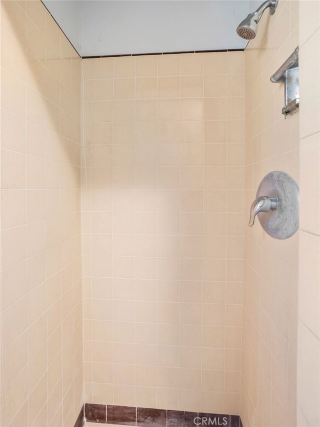 interior details with a tile shower