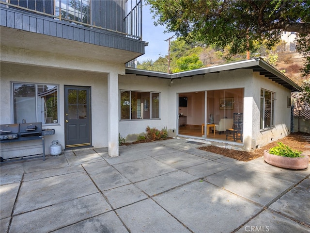 rear view of property featuring a patio area and a balcony