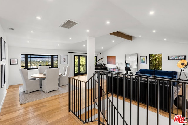 interior space with light hardwood / wood-style flooring and lofted ceiling with beams