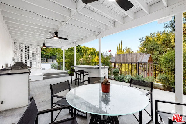 view of patio with ceiling fan and an outdoor bar