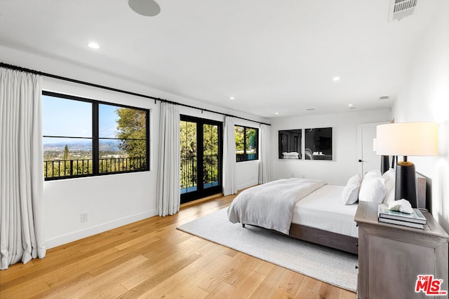 bedroom featuring access to outside, french doors, and light hardwood / wood-style floors