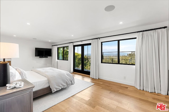 bedroom featuring access to exterior and light wood-type flooring