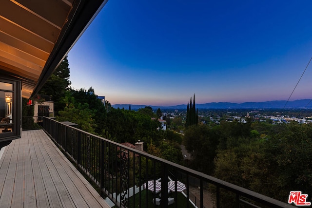 deck at dusk featuring a mountain view