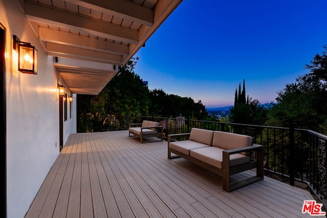 deck at dusk featuring an outdoor living space