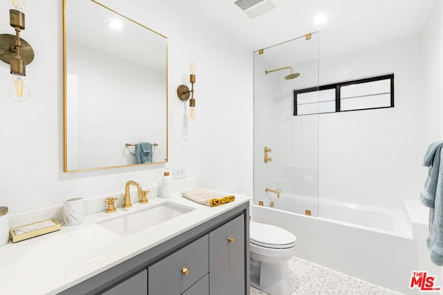 full bathroom featuring toilet, tiled shower / bath, and vanity