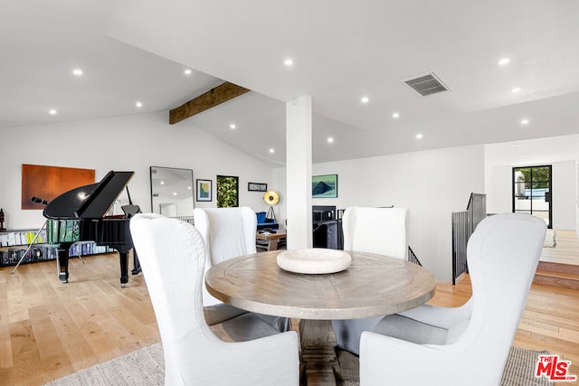 dining room with light hardwood / wood-style floors and vaulted ceiling with beams