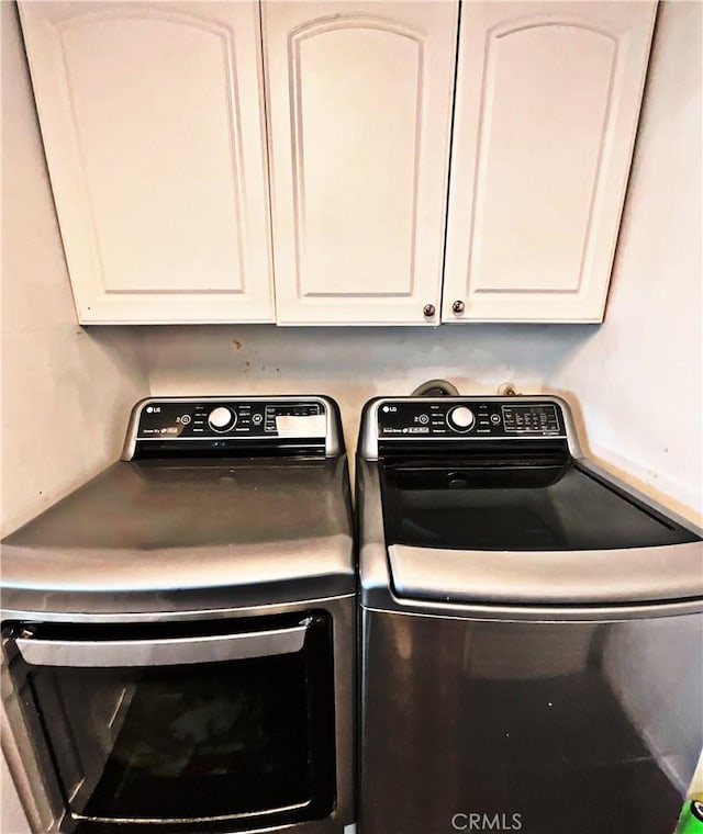 laundry area featuring washing machine and dryer and cabinets