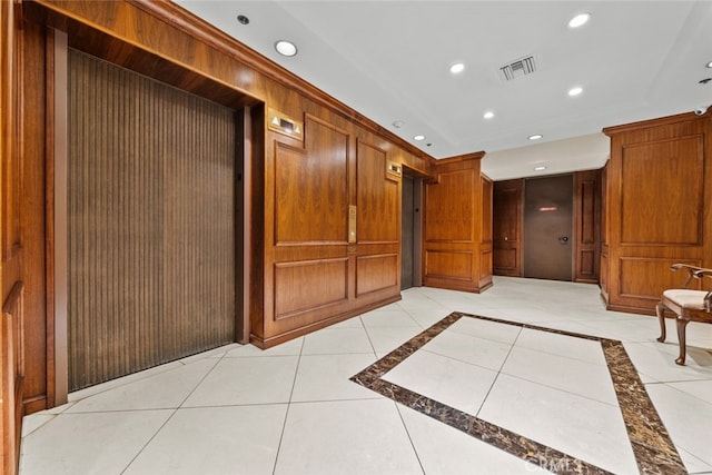 hall featuring light tile patterned floors and elevator