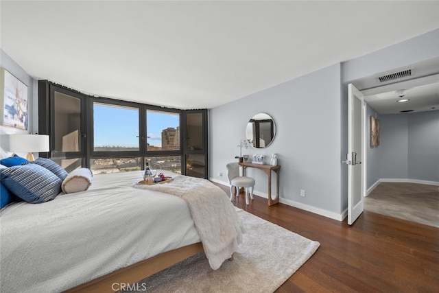 bedroom featuring dark hardwood / wood-style flooring and floor to ceiling windows