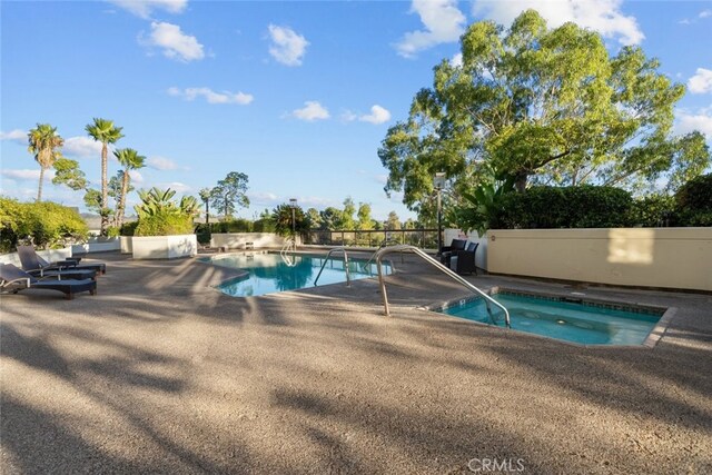 view of swimming pool featuring an in ground hot tub and a patio