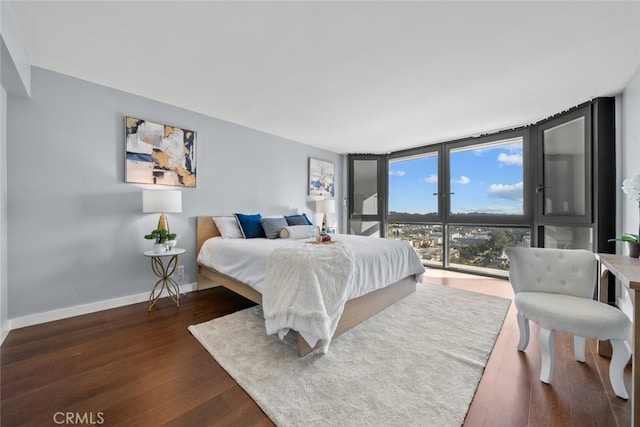 bedroom featuring dark hardwood / wood-style floors and expansive windows