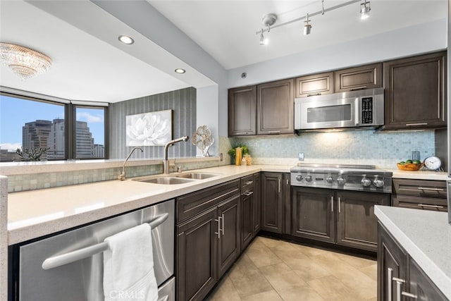 kitchen featuring appliances with stainless steel finishes, dark brown cabinetry, sink, backsplash, and light tile patterned floors