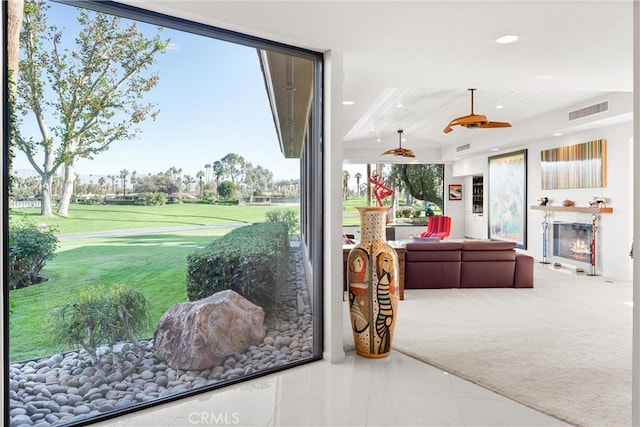 interior space with a glass covered fireplace, recessed lighting, visible vents, and carpet floors