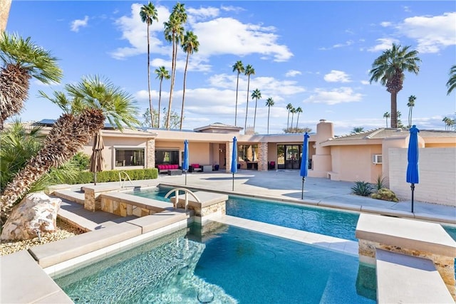 outdoor pool with a patio area and an in ground hot tub