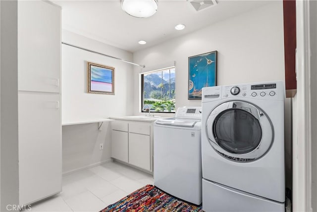 clothes washing area with light tile patterned floors, recessed lighting, washer and dryer, cabinet space, and a sink