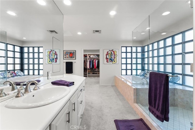 bathroom with vanity, a bath, recessed lighting, and visible vents