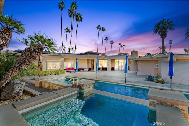 view of pool with a patio and a pool with connected hot tub