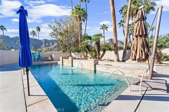 view of swimming pool featuring a mountain view, a fenced backyard, and a patio area