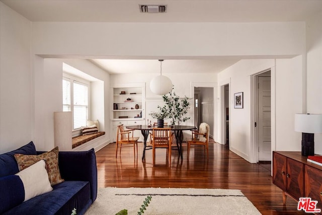 dining space with built in features and dark hardwood / wood-style flooring