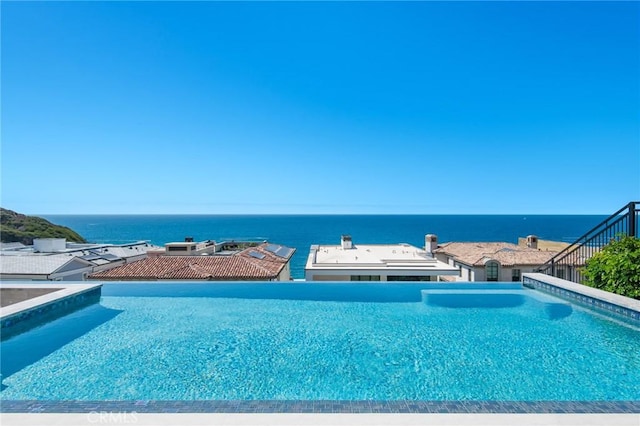 view of pool with an infinity pool and a water view