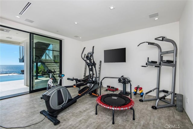 exercise room with a water view