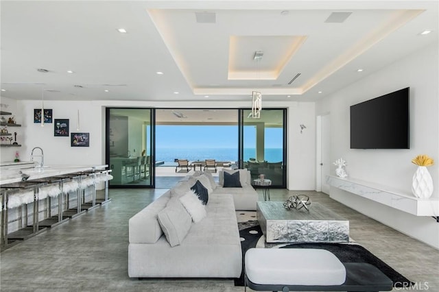 living area featuring visible vents, floor to ceiling windows, a tray ceiling, and recessed lighting