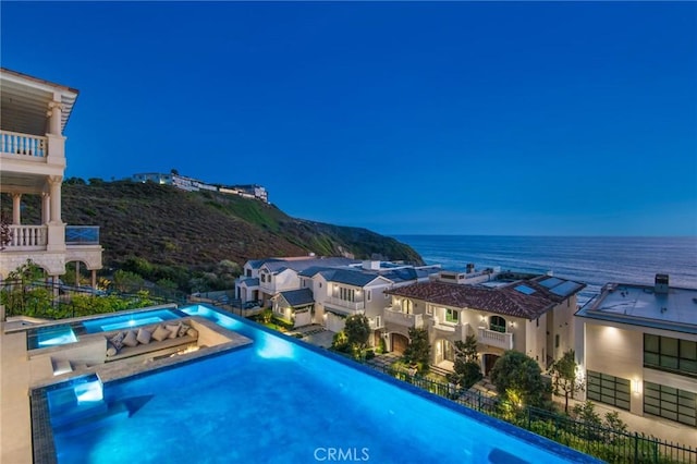 view of swimming pool with a water view, fence, and a fenced in pool