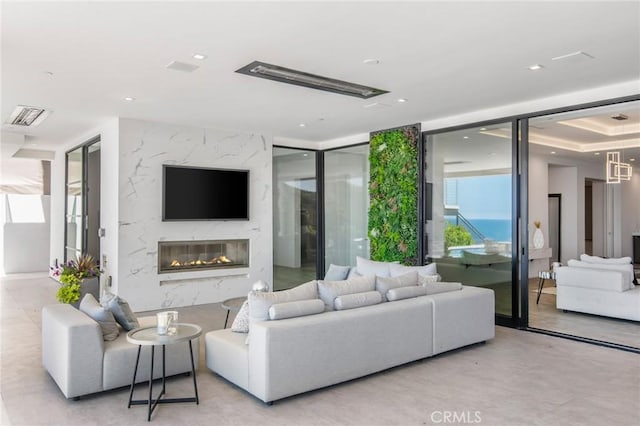 living room with floor to ceiling windows, a premium fireplace, visible vents, and recessed lighting